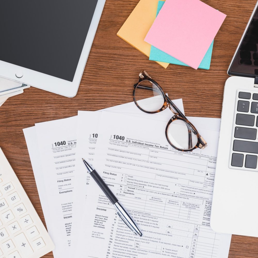 top-view-of-tax-forms-digital-devices-and-stationery-on-desk.jpg